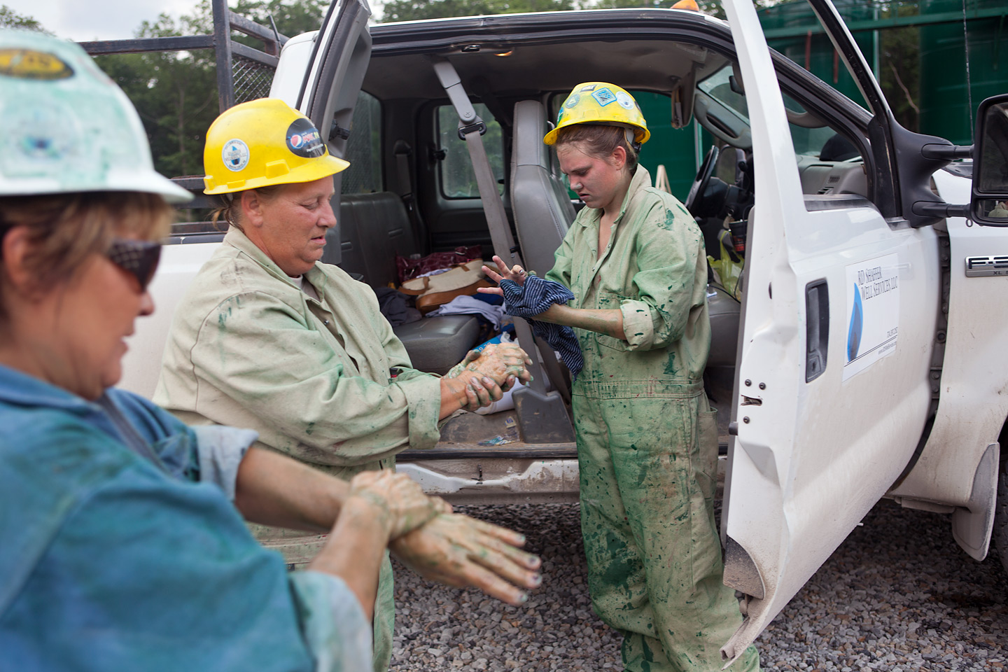 Workers clean up after a day spent spray painting green paint on gas well pads throughout Moshannon State Forest in Clearfield County, Pennsylvania.